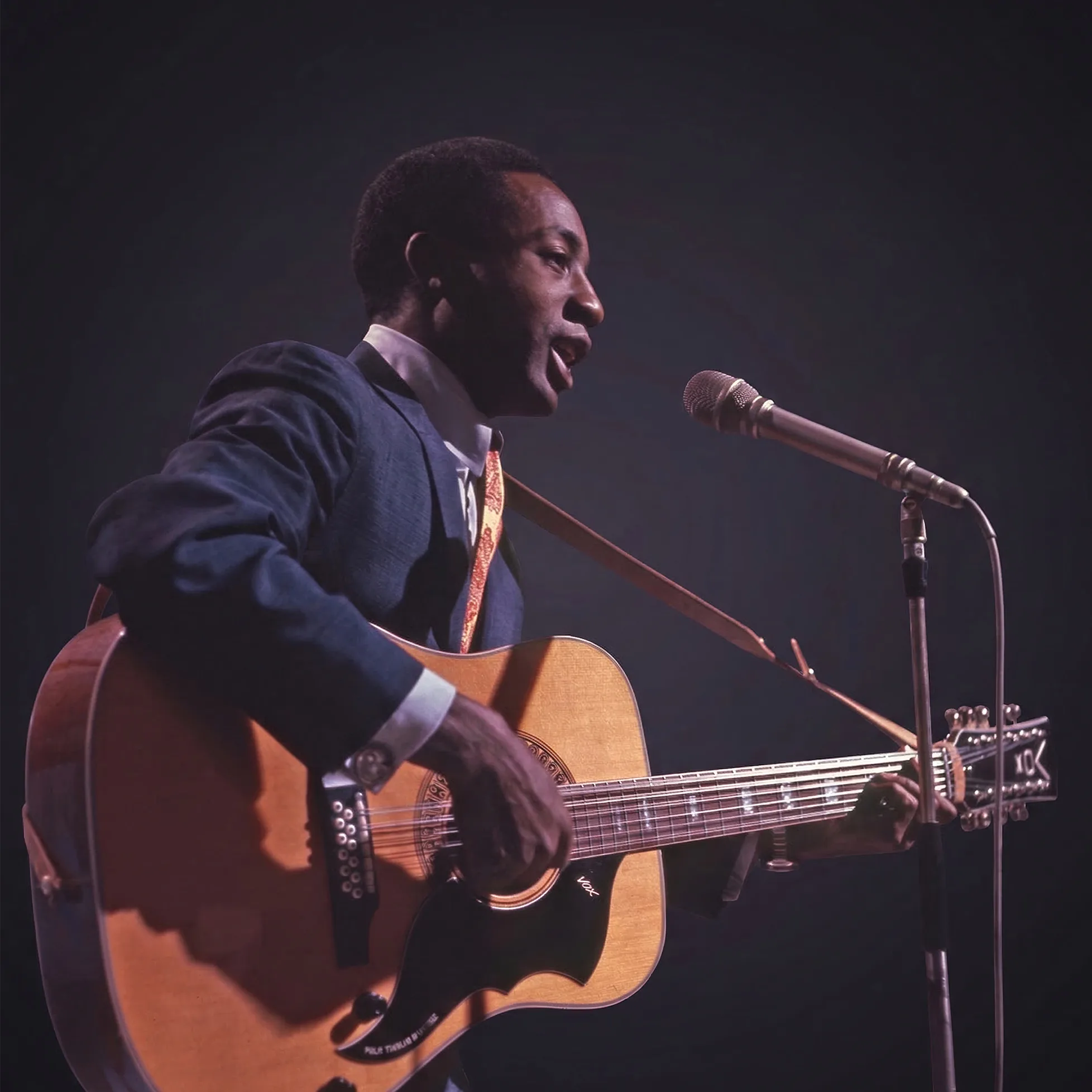 Bobby Hebb performing live with acoustic guitar, singing into a microphone while playing.