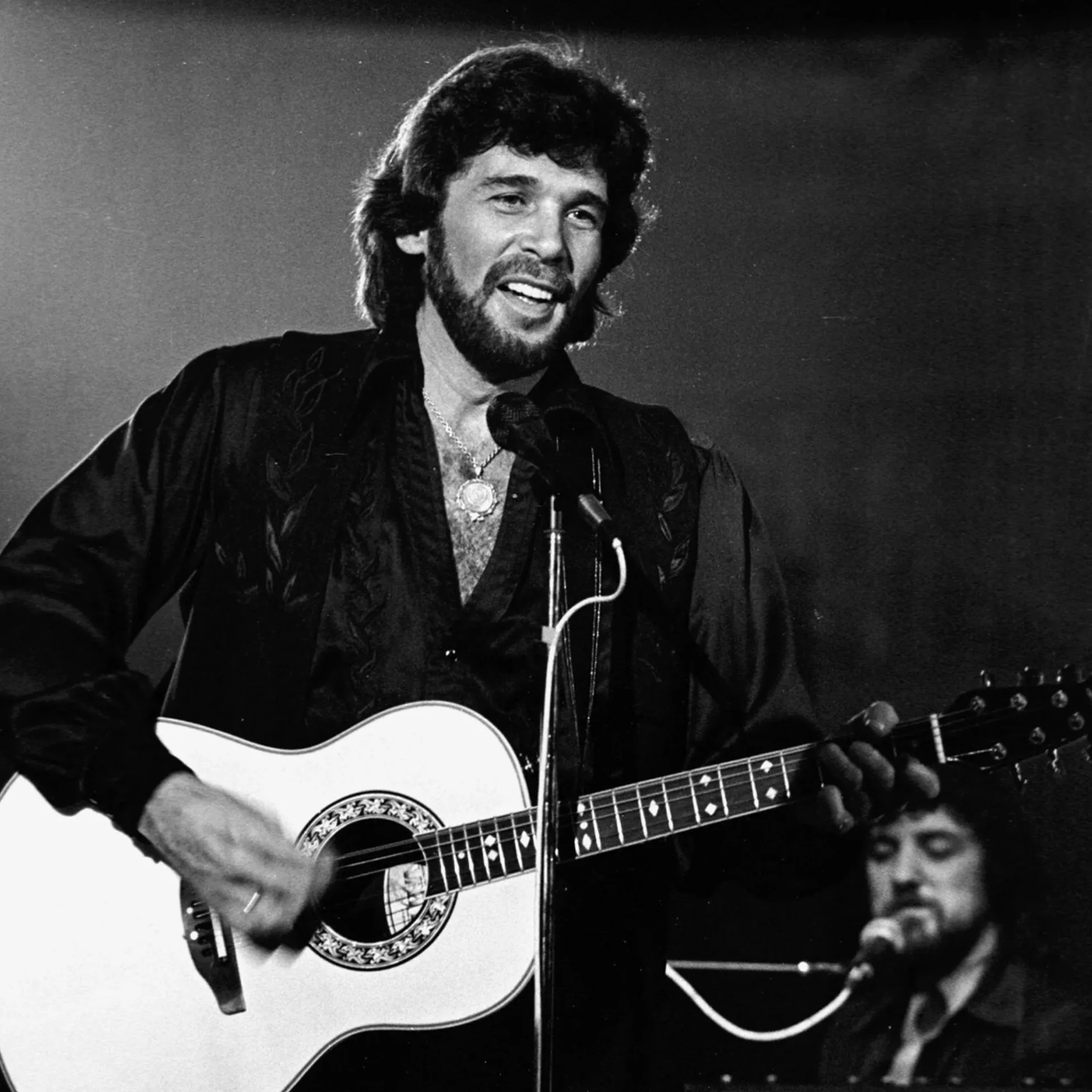 Eddie Rabbitt performing with acoustic guitar.