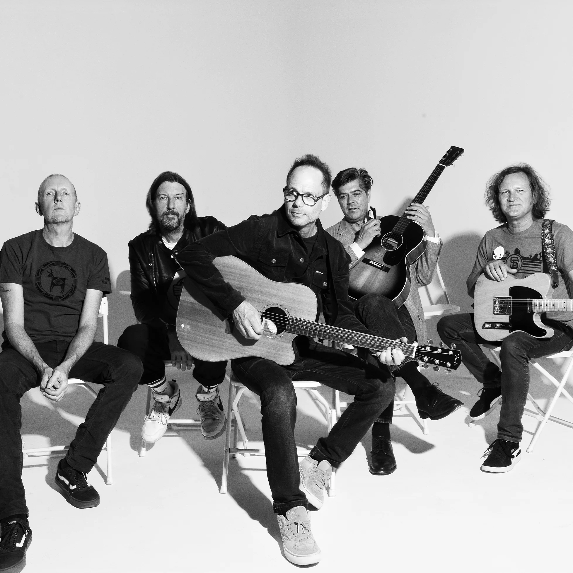 Gin Blossoms sitting portrait with guitars.