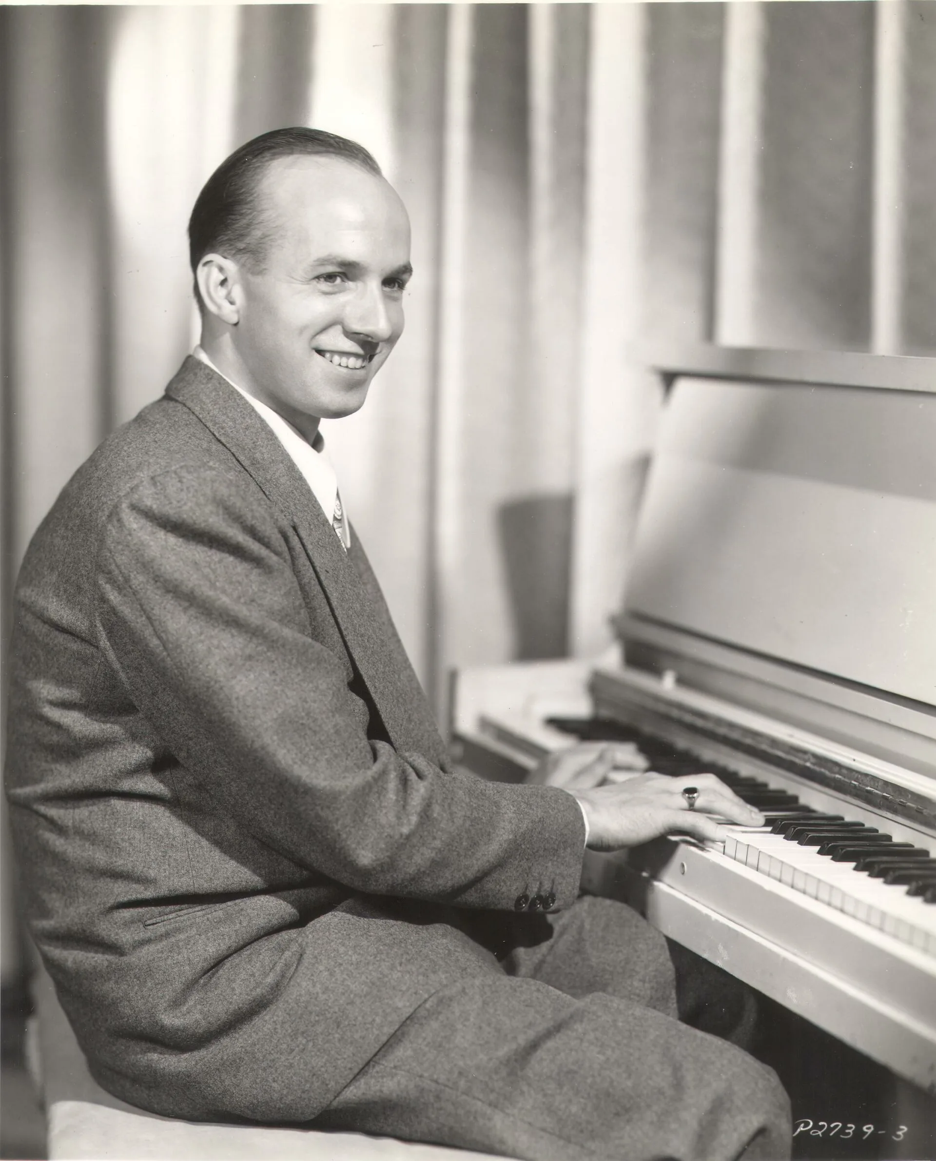 A black and white photograph of Jimmy Van Huesen seated at a piano.