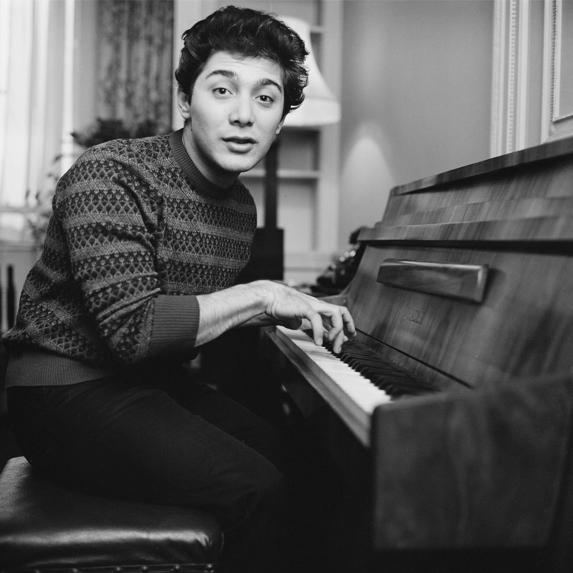 Young Paul Anka seated at a piano.