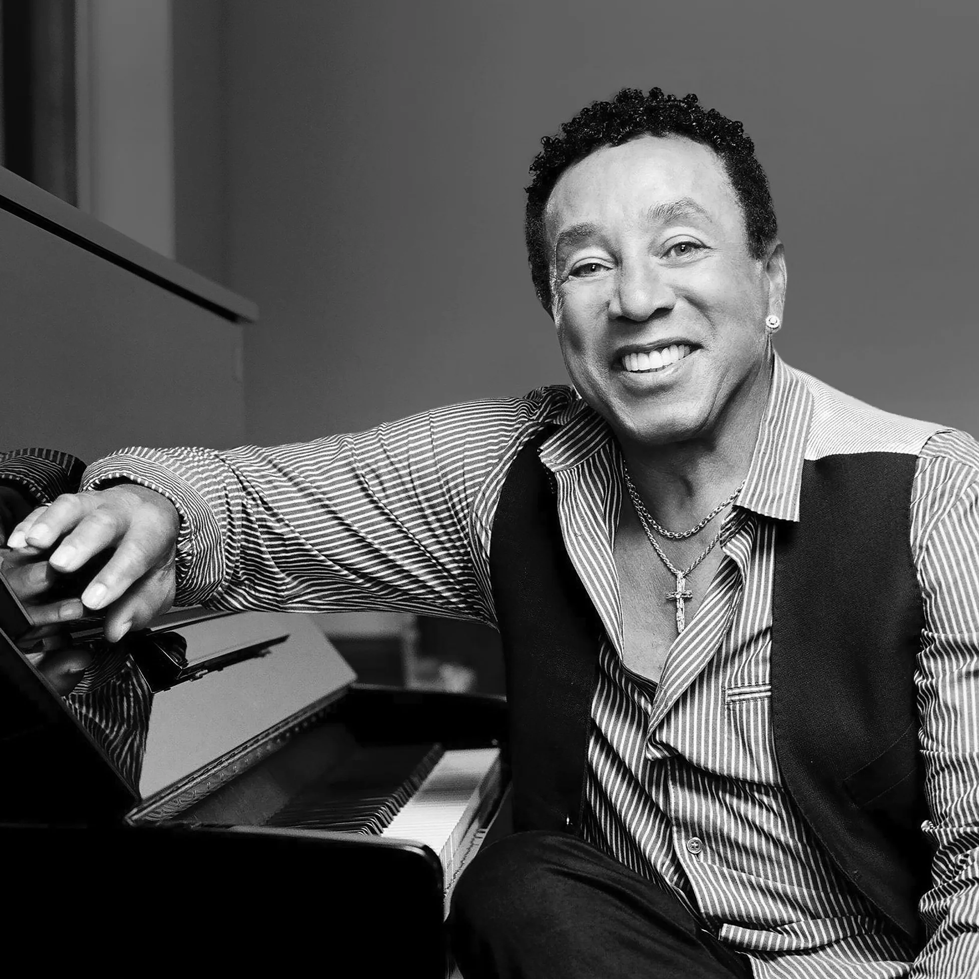 Smokey Robinson smiling at piano.