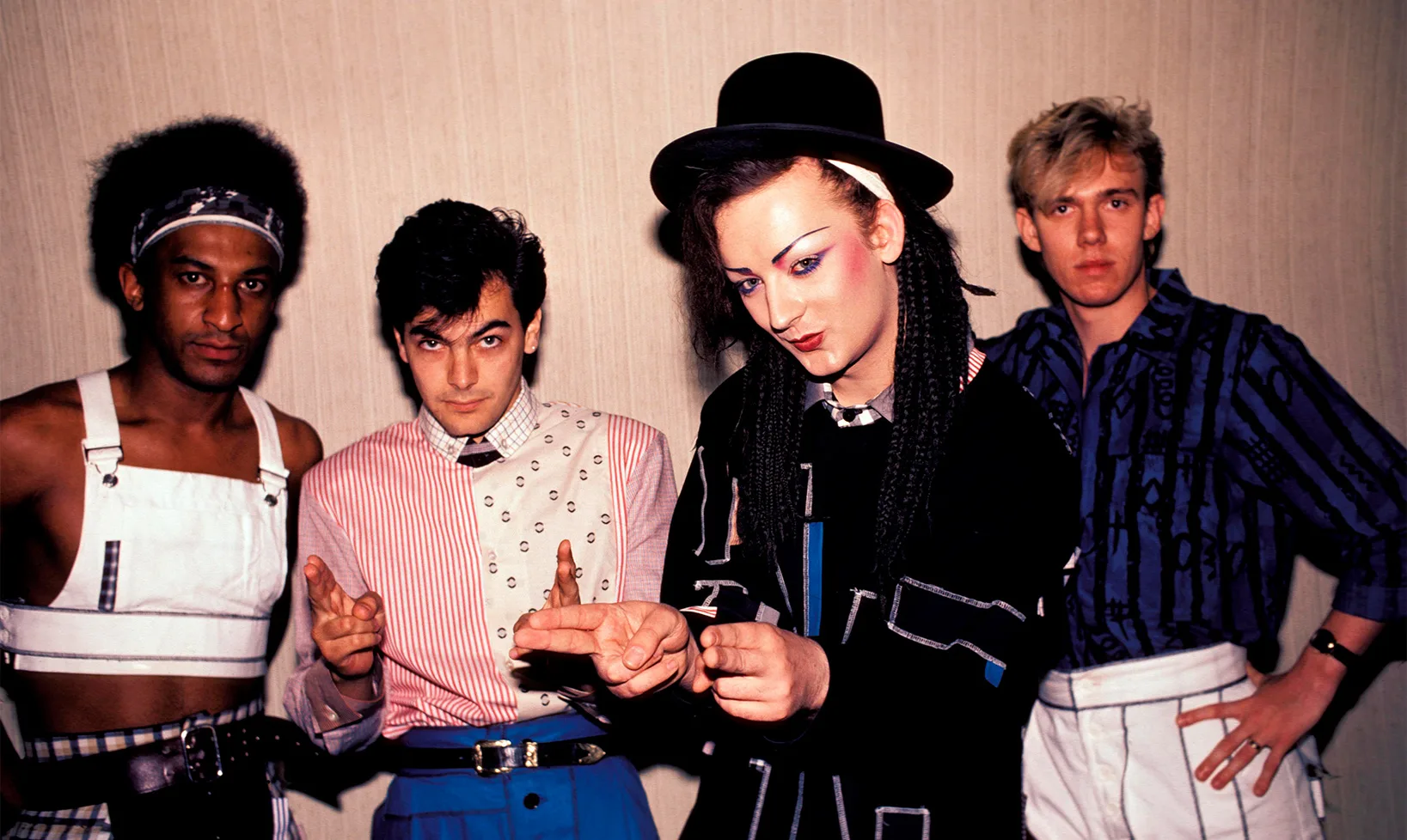 Culture Club 1980s classic group portrait: Boy George in black bowler hat and braids with dramatic makeup, flanked by bandmates.